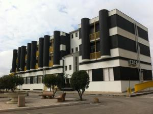 a black and white building with benches in front of it at Hotel Atleti - RICARICA AUTO ELETTRICHE - in Foggia