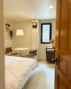 a bedroom with a bed and a table and chair at 포켓서울 여의도 in Seoul