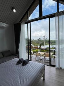 a bedroom with a bed and a view of a patio at River Hill Khaokho in Khao Kho