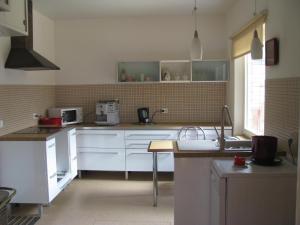 a kitchen with white cabinets and a sink at Soliid Apartment in Pärnu