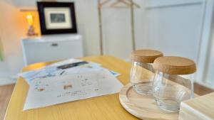 een houten tafel met een glazen vaas en twee kurken stoppers bij 民泊&guest house NOOK NOOK ディズニーまで往路のみ無料送迎 in Tokyo +35 foto's
