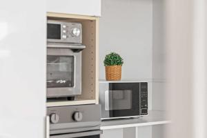a kitchen with a microwave and a potted plant at Homely Private Double Room in Marsfield - Well-Connected Suburb Shared Bathroom in Epping