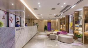 a hotel lobby with a reception counter and purple furniture at Lavande Hotels Wuhan Guanggu Yangjiawan Metro Station in Wuhan
