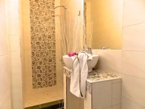 W łazience znajduje się umywalka oraz prysznic z ręcznikiem. w obiekcie Filippos Resort II by Karidi w mieście Vourvourou