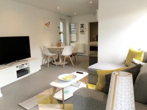 a living room with a couch and a tv at Le Coin Cocoon Bis in Aywaille