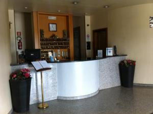 eine Lobby mit einer Theke in einem Gebäude mit Blumen in der Unterkunft Hotel Atleti in Foggia