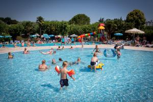 un groupe de personnes dans une piscine dans l'établissement Camping Fossalta, à Lazise
