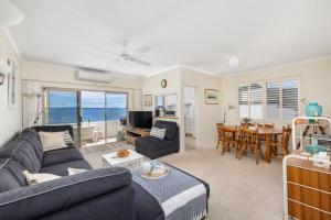 una sala de estar con un sofá y una mesa en Del Rae Waterfront Shoal Bay, en Shoal Bay