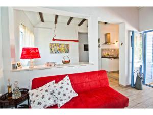 um sofá vermelho numa sala de estar com uma cozinha em Villa Romansa near Split- heated pool peace, bbq em Krušvar