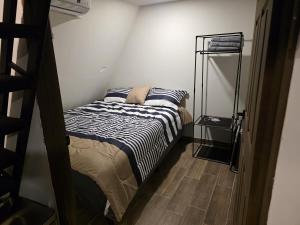 a small bedroom with a bed and a ladder at Cozy A-Frame Beach Cabin Sihu-A Casa in Las Piedras