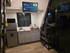 a kitchen with a refrigerator and a sink at Cozy A-Frame Beach Cabin Sihu-A Casa in Las Piedras