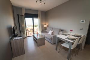 Una sala de estar con un sofá y una mesa con televisión. en Hotel Miguel Sanchez, en Alhaurín de la Torre
