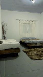 Dos camas en una habitación con dos alfombras. en Espaço fazendinha por do Sol da piscina, en Paty do Alferes