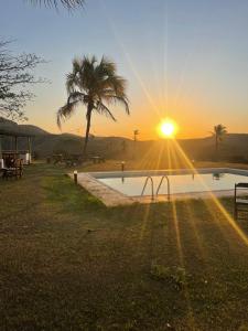 Una puesta de sol con una palmera y una piscina. en Espaço fazendinha por do Sol da piscina, en Paty do Alferes 26 fotos más