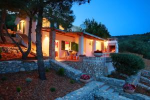 a house with a stone wall in front of it at Villa Sol in Vinišće