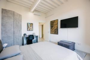 a bedroom with a bed and a tv on the wall at Palace d'Art - Centro Storico di Arezzo in Arezzo