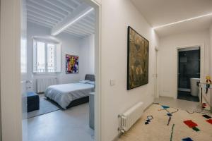 a white bedroom with a bed and a bathroom at Palace d'Art - Centro Storico di Arezzo in Arezzo