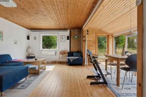 a living room with a blue couch and a table at Holiday Home On Adventurous Plot Near Beach in Fårevejle