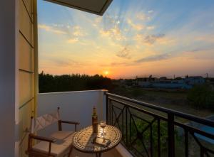 a balcony with a table and a bottle of wine at Sunny Breeze Deluxe Villa Near Beach, Private Pool in Kremasti