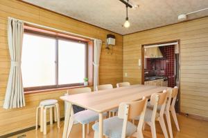 een eetkamer met een houten tafel en stoelen bij Nakajima Park West House / Vacation STAY 5418 in Sapporo