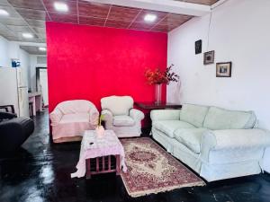 a living room with two couches and a red wall at JK Residence in Nugegoda