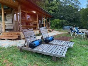 Upper BurringbarにあるEagles Rest -4WD AWD access -a private retreat for two-の小屋の前のベンチに置かれた2脚の椅子