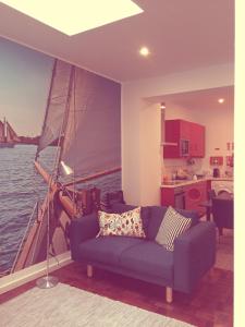a living room with a blue couch and a sail boat at Casa dos Pátios II in Aveiro