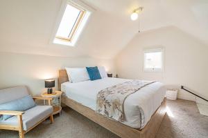 una camera da letto con un letto grande e una sedia di Dolly's Cottage - Timeless Retreat near Hobart CBD a Hobart