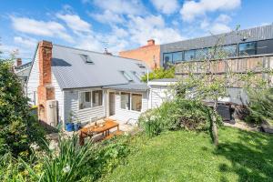 una casa bianca con un giardino di fronte a un edificio di Dolly's Cottage - Timeless Retreat near Hobart CBD a Hobart