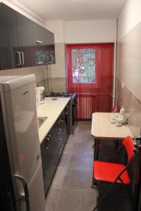 een kleine keuken met een tafel en een rood raam bij Studio Lujerului 2 in Boekarest