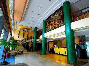 a lobby with green columns and a painting on the wall at MO2 Westown Hotel San Juan in Bacolod +200 photos