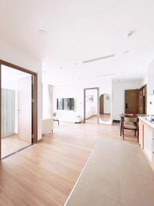 an empty living room with a wooden floor and a table at 西贡生态绿洲公寓EcoGreen-E in Ho Chi Minh City