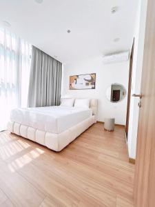 a white bedroom with a large white bed in it at 西贡生态绿洲公寓EcoGreen-E in Ho Chi Minh City