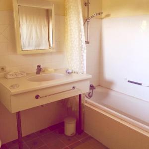 La salle de bains est pourvue d'un lavabo et d'une baignoire. dans l'établissement Coeur De Beaujolais, à Corcelles-en-Beaujolais