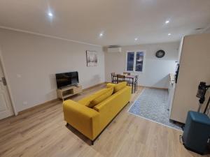 a living room with a yellow couch and a television at appartement vezzani in Vezzani