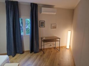 a bedroom with a table and a window with blue curtains at appartement vezzani in Vezzani