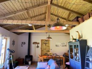 a living room with wooden ceilings and a table at The Cabin at Tedburrow rural retreat perfect for couples in Culmstock