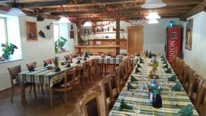 uma grande sala de jantar com mesas longas e cadeiras em Tourist Farm Pri Požarju em Knežak