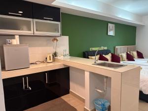 - une cuisine avec évier et un lit dans une chambre dans l'établissement The Viana Apartment 3, à Kota Bharu