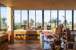 チャングーにあるTUI Blue Berawa Boutique Villaの大きな窓と食べ物が置かれたテーブルのあるキッチン