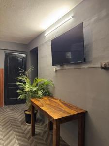 salon z drewnianym stołem i telewizorem z płaskim ekranem w obiekcie Secret Suites - Love Making Romatic Abode w mieście Gurgaon