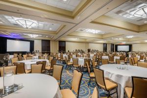 a large room with tables and chairs and a projection screen at Omni Charlotte Hotel in Charlotte +110 photos