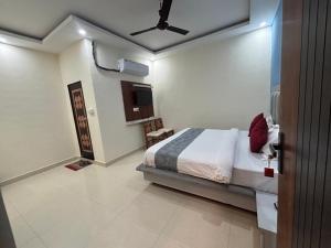 a bedroom with a bed and a ceiling fan at Hotel Tirth Heritage Step Away from Ram Mandir in Jāmb