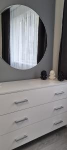 a white dresser with a mirror on top of it at Квартира біля озера, в парку Загребелля in Ternopilʼ