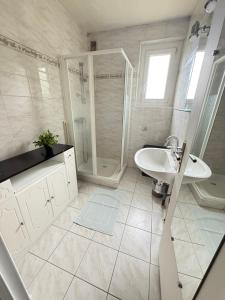 a white bathroom with a shower and a sink at Tout le monde sous le meme toit - 10 voyageurs - 25 mn europapark in Benfeld +16 photos