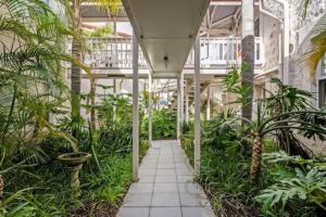 an indoor garden with palm trees and a walkway at Sea Breeze at Smugglers Inn in Victor Harbor