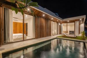 una piscina cubierta en una casa por la noche en New cozy 2-Bedroom Ocean View Villa, en Uluwatu