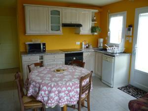 a kitchen with a table and a kitchen with yellow walls at Briois Cristelle in Penmarch