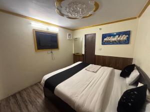 a bedroom with a bed and a flat screen tv at Retreat HRH Hotel in Nainital +6 photos