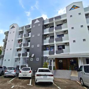 a large building with cars parked in a parking lot at Amina Residence in Ban Sai Ma